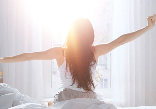 Woman stretching in bed