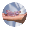 Hand holding a lavender oral appliance