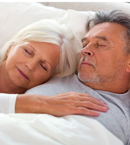 Senior man and woman sleeping soundly after treating obstructive sleep apnea in Mesa