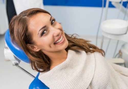 Smiling young woman leaning back in dental chair