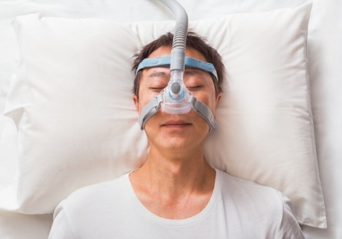Sleeping man wearing a C P A P mask over his face